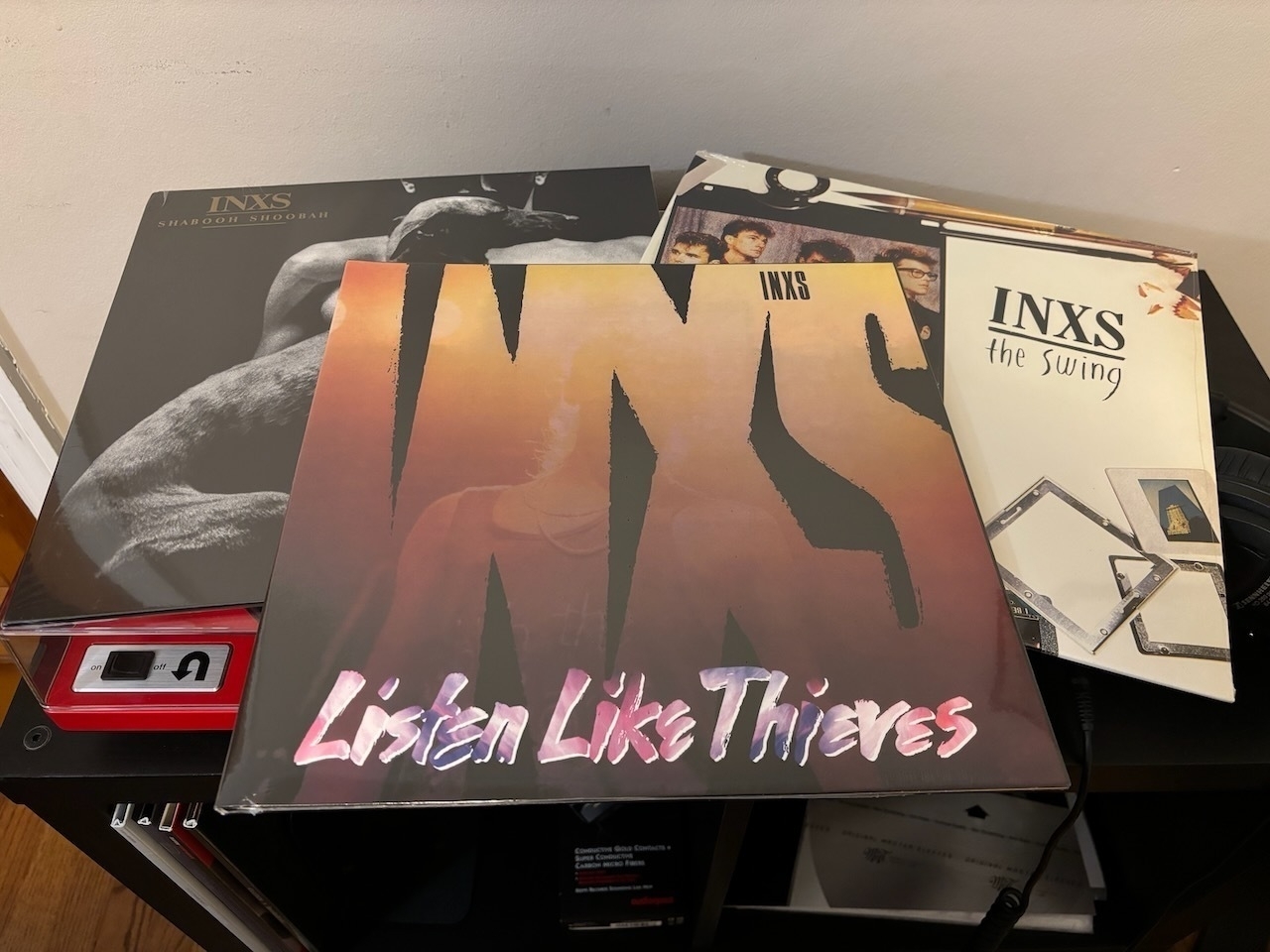 Auto-generated description: A collection of INXS vinyl records is arranged on a table.
